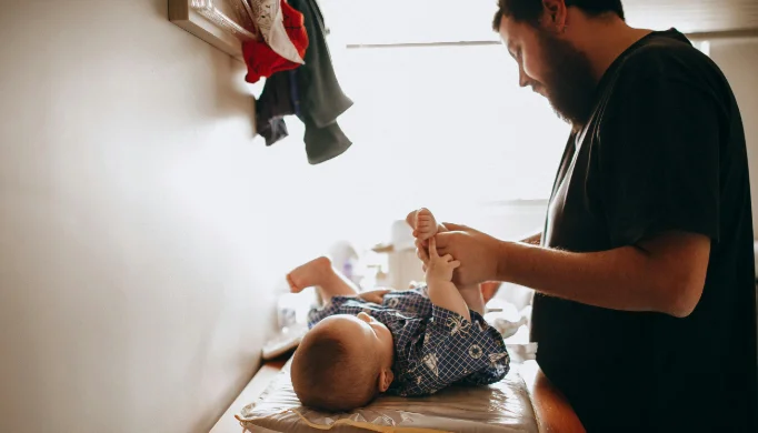 father changing baby's diaper